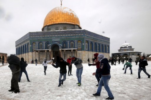 people-play-in-the-snow-in-front-of-the-dome-of-the-rock-inside-the-al-aqsa-mosque-compound-in-j.jpg